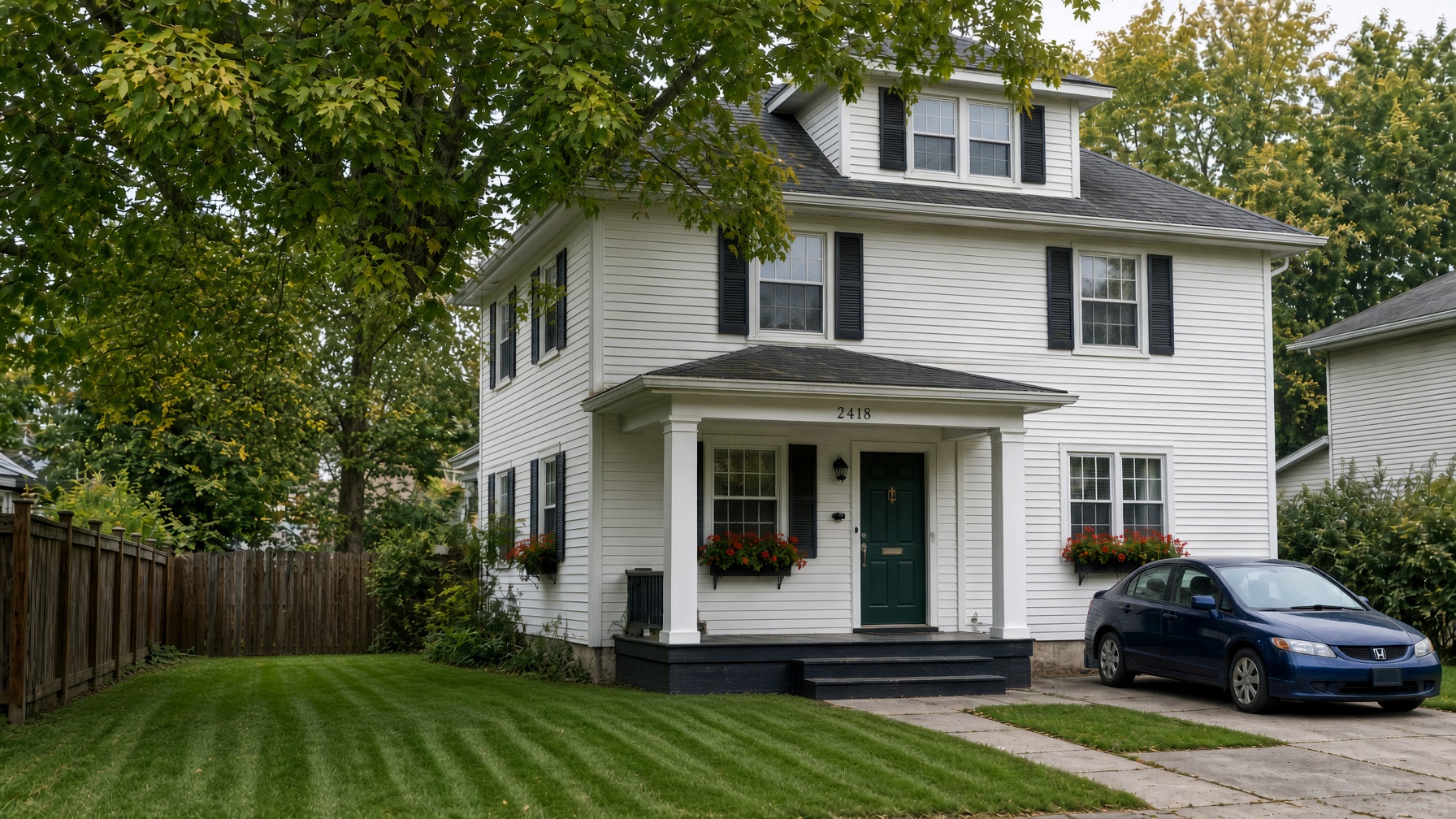 Same Green Bay colonial after the large maple was removed, yard left in grass